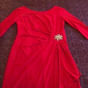 Red cocktail length evening dress with brooch